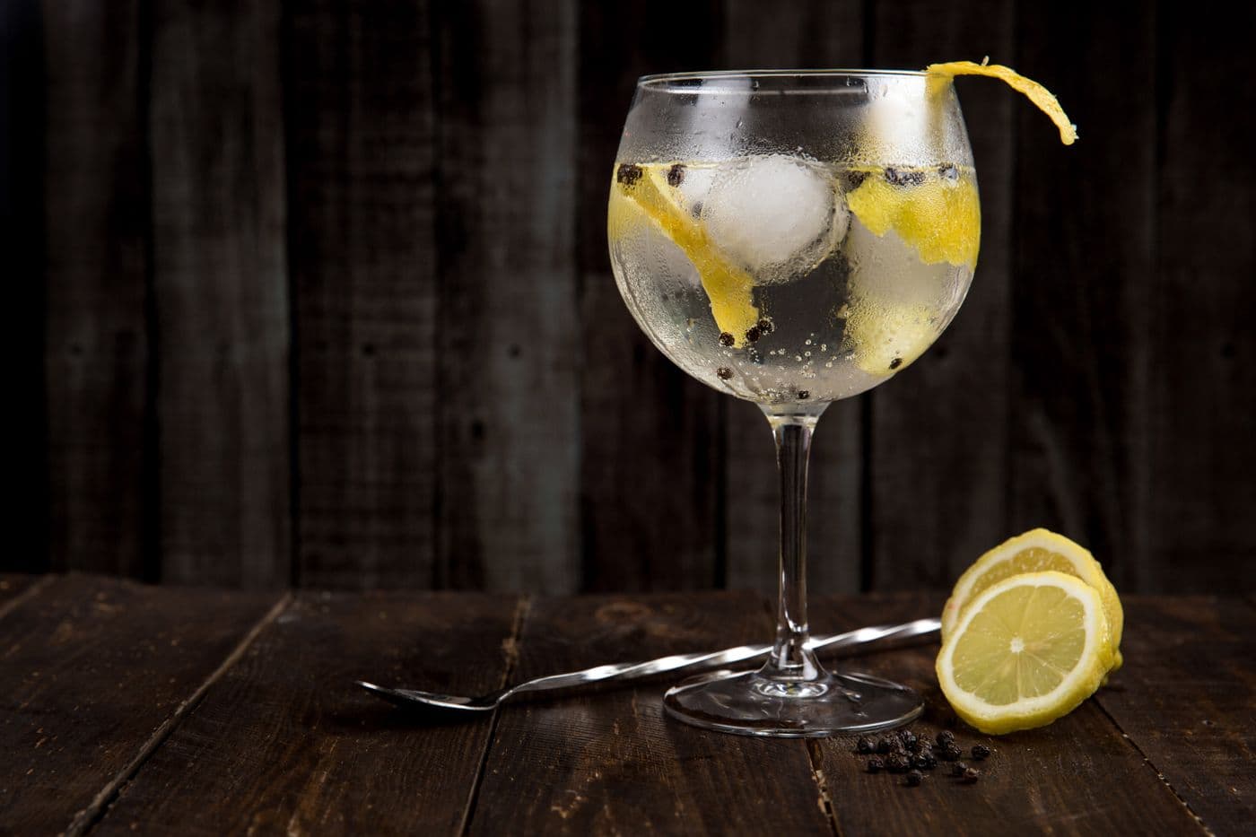 Stock photograph of a clear drink with ice and lemon peel
